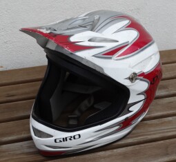 Celotvářová (full‑face) helma s kšiltem, typická pro downhill MTB nebo motokros.