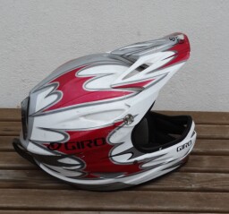 Celotvářová (full‑face) helma s kšiltem, typická pro downhill MTB nebo motokros.